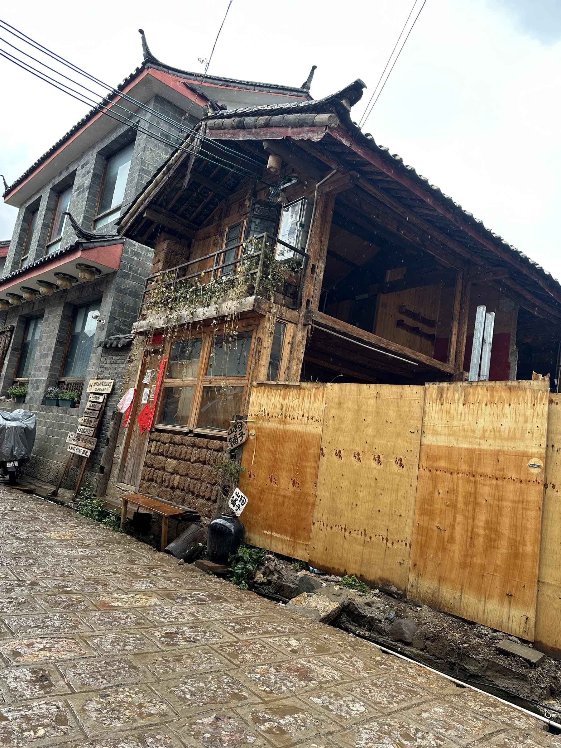 Weathered timber houses along a narrow lane in Dali