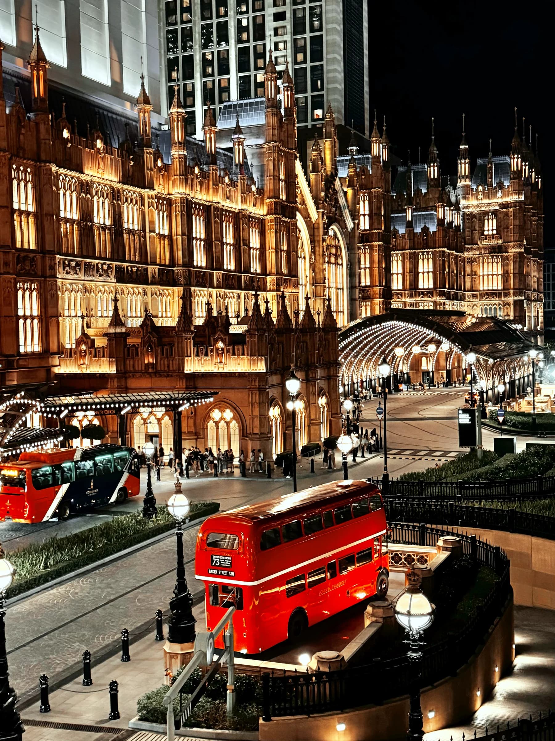An ornate London-themed facade and red vehicle illuminated at night in Macao